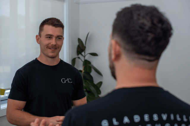 2 male therapists discussing chiropractic treatment at Gladesville Healthcare