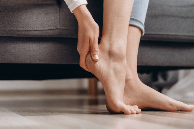 Female holding her heel in pain with Plantar Fasciitis