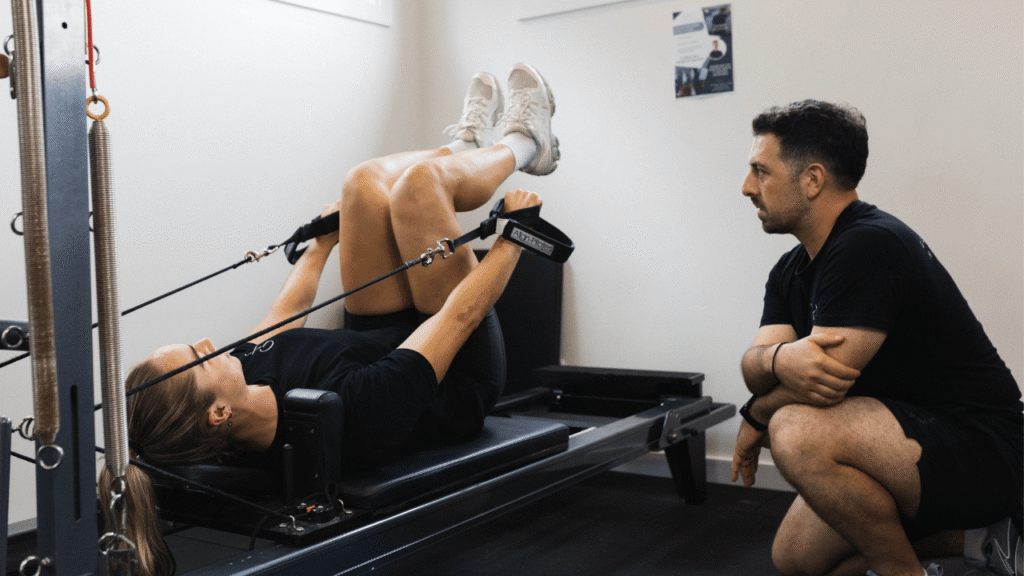 Marcus Drivas instructing Kezie Apps on the Reformer at Gladesville Healthcare