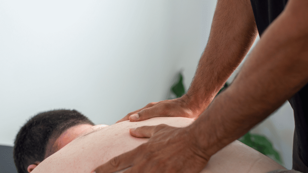 Person receiving a back massage from another person with both hands.