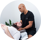 A practitioner performs a neck adjustment on a patient lying on a treatment table.