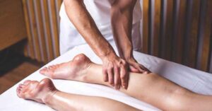 Person receiving a leg massage comparing Deep Tissue vs Remedial Massage techniques.